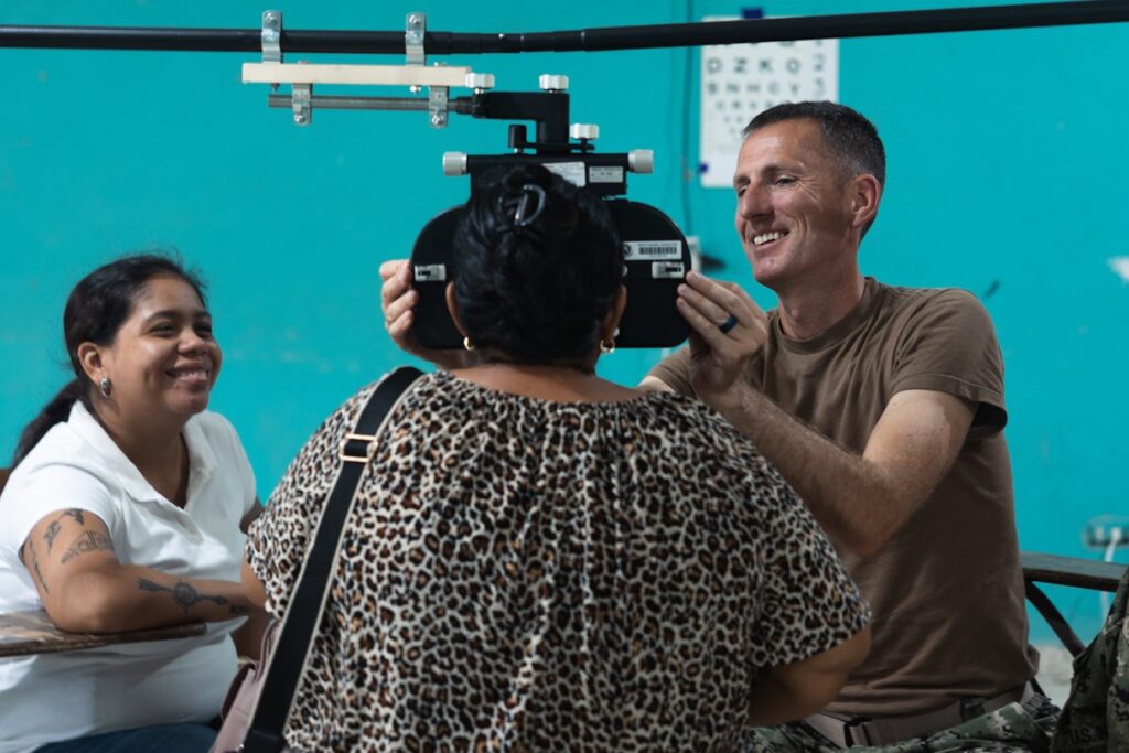 Eye care professional positioning vision-testing equipment for a patient during an eye exam