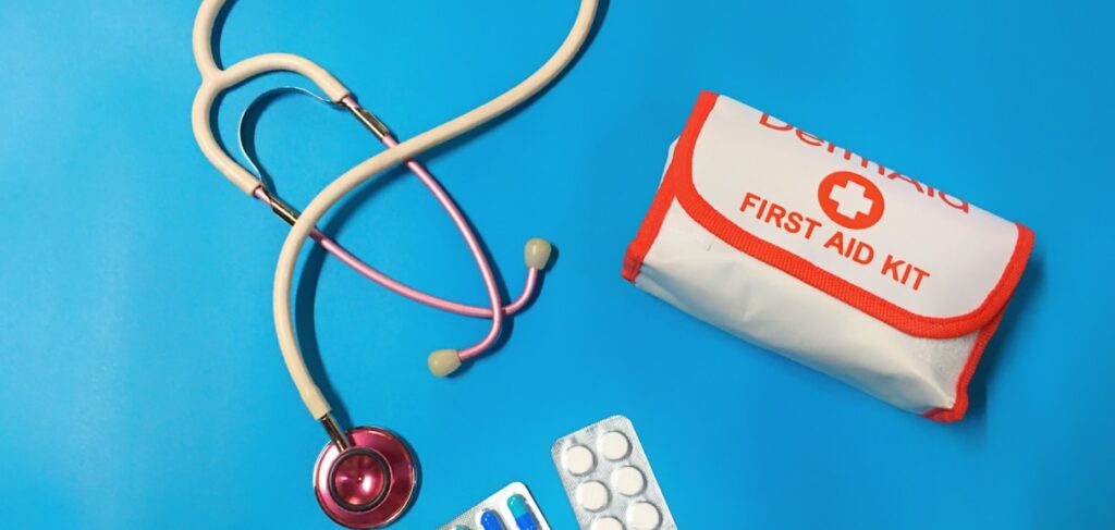 First aid kit, stethoscope, and medication on a blue background