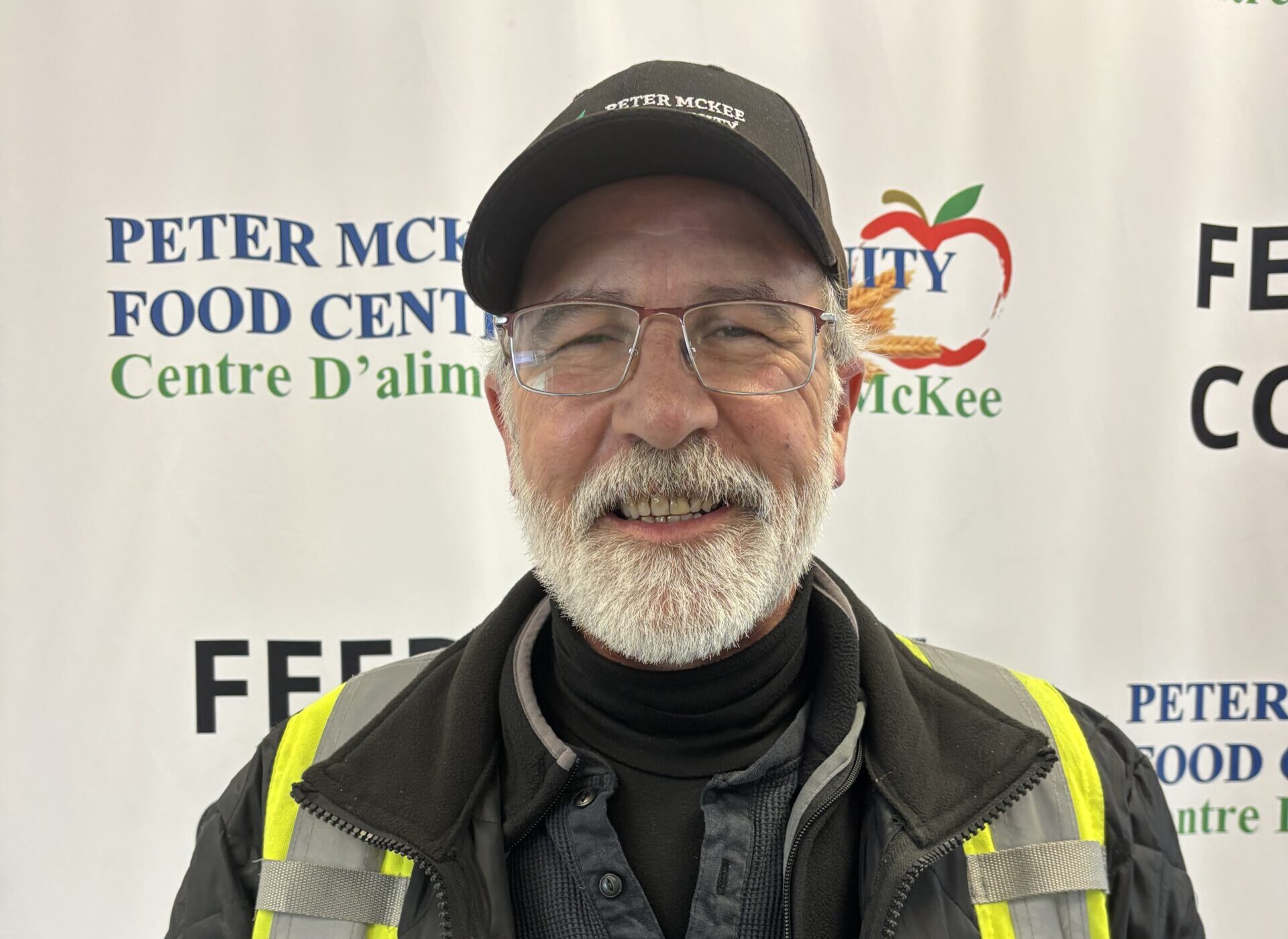 Portrait of a Peter McKee Community Centre team member wearing a cap and safety vest