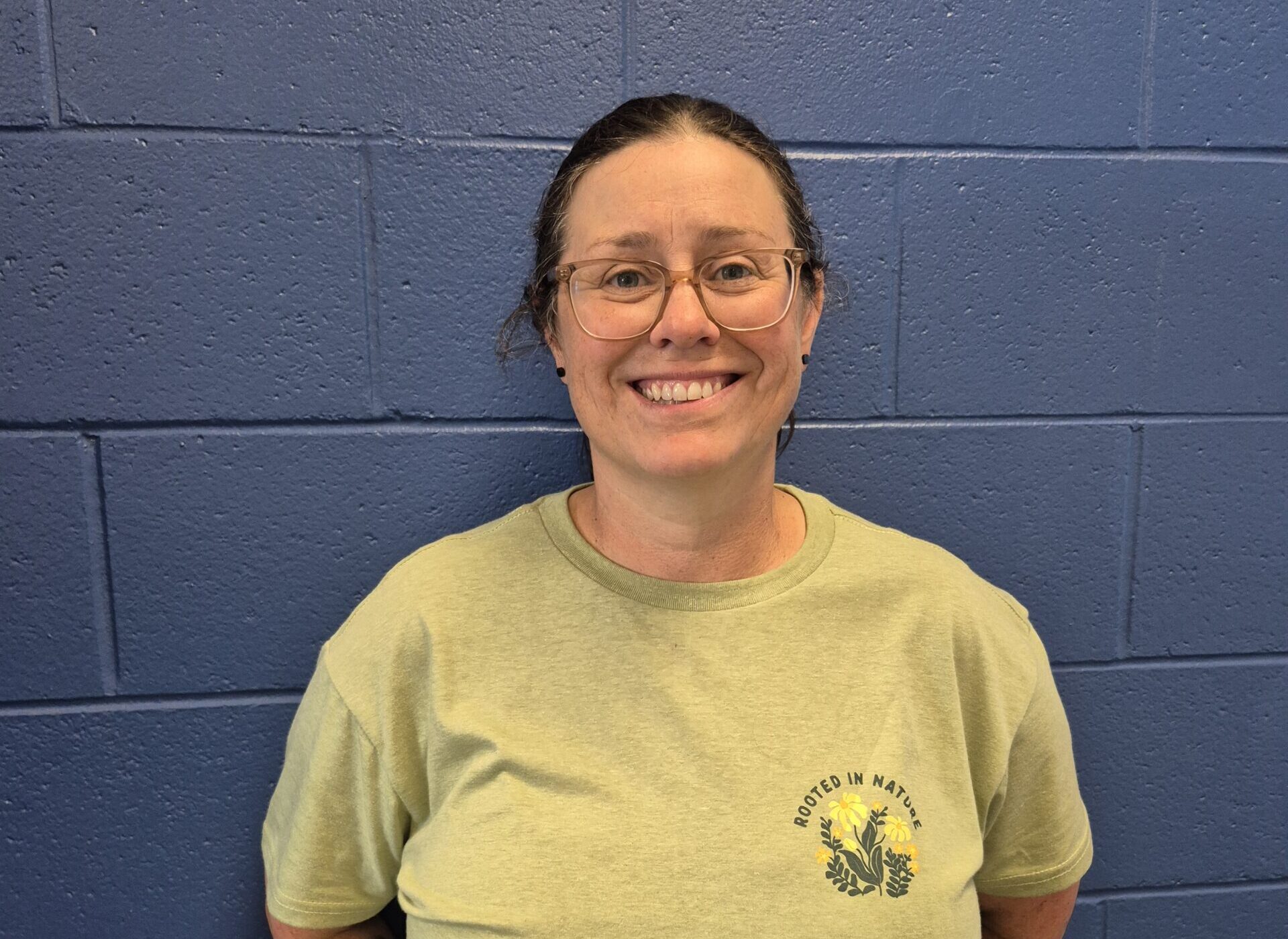 Portrait of a Peter McKee Community Centre team member wearing glasses and a green shirt